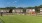 a large green field with houses in the background