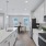 Model kitchen at one of our townhomes for rent in Waldorf, MD, featuring wood grain floor paneling and white counters.