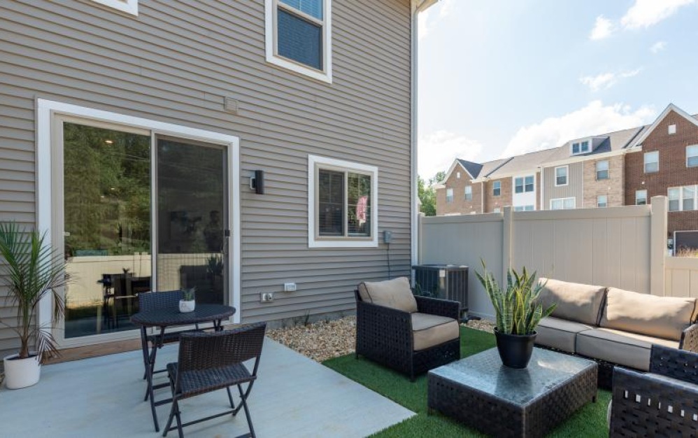 a patio with a table chairs and a patio with a glass door