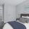 Model bedroom at our townhomes for rent in Waldorf, MD, featuring white bedspread and a view of the closet.
