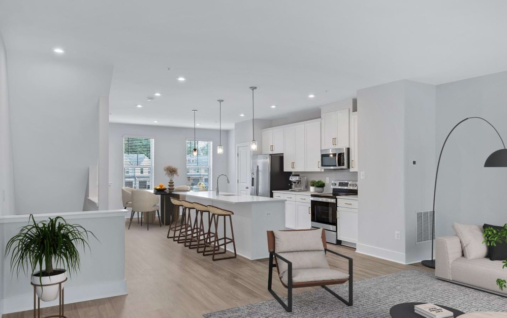 Model living room and kitchen at our townhomes for rent in Waldorf, MD, featuring wood grain floor paneling and modern decor.