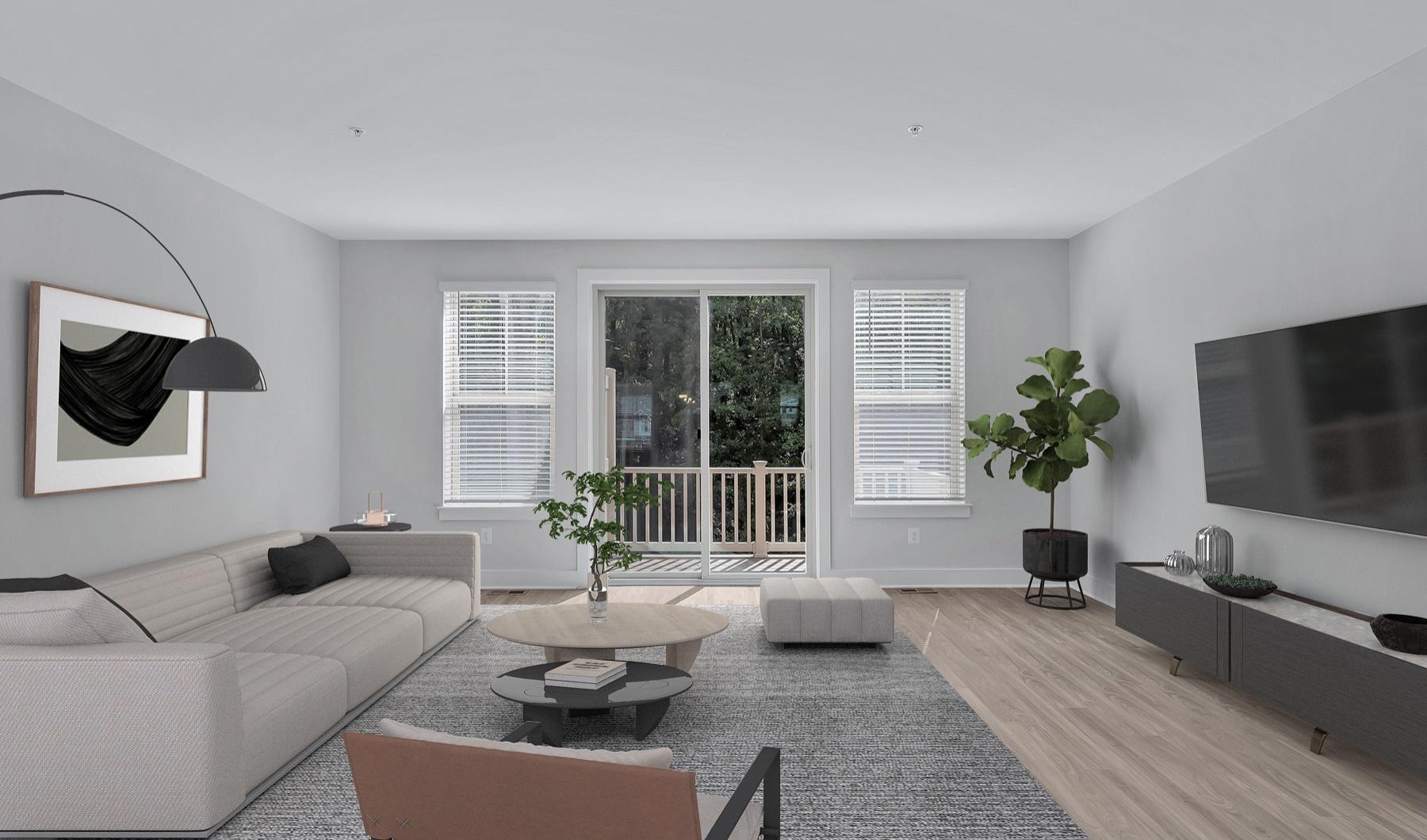 Model living room at Brookestone Townhomes for rent in Maryland, featuring wood grain floor paneling and a flat screen TV.